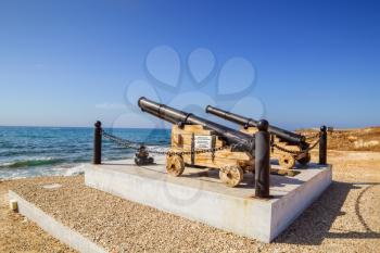 Old cannon ball guns monument by the Paphos castle on the sea shore, Cyprus.