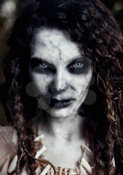 Halloween theme: creepy grim voodoo witch. Close-up portrait of the evil sorceress. Zombie woman (undead)
