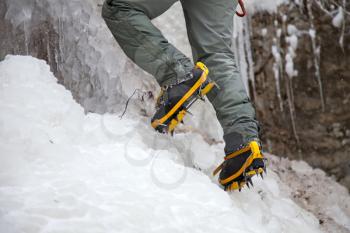 Royalty Free Photo of a Man With Ice Axes and Crampons Climbing on Ice Fall
