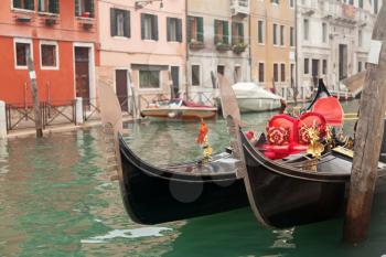 Two gondola in Venice near pier in channel
