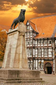 Lion statue and old timbered house in Braunschweig, Germany at sunset
