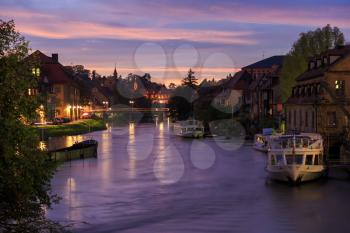Cloudy sky at sunset, Regnitz river with ships in Bamberg, Germany
