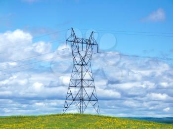 Royalty Free Photo of a Power Tower on a Hill Against a Blue Sky