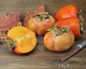 Royalty Free Photo of Persimmon Fruits On Wooden Background