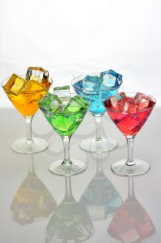 arrangement of colorful cocktails with ice cubes