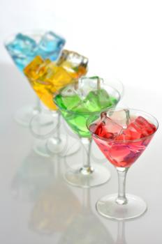 glasses of colorful drinks with ice cubes