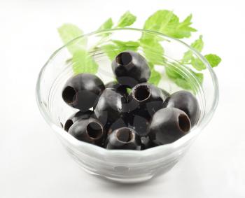 black olives in a glass bowl , close up