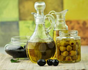 A bottle of olive oil with black and green olives
