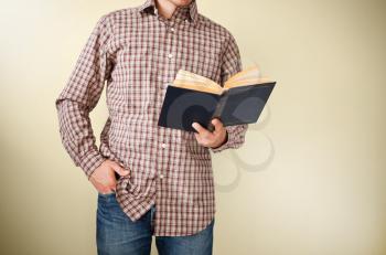 Man in brown plaid shirt reading a book