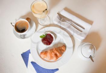 Continental breakfast. Freshly baked croissants with jam, strawberries, coffee and orange juice. 
