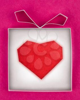 Hand made gift box with heart inside, textured  paper as background. Greeting card 