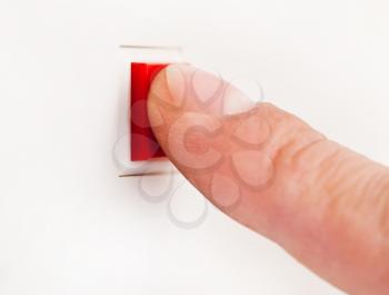 Finger pushing a red button 