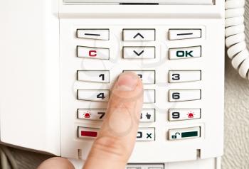 Closeup of a person entering a pin code to a home alarm 