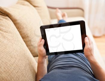 Man relaxing with tablet pc, laying on sofa