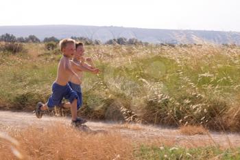 Two young children running in the nature