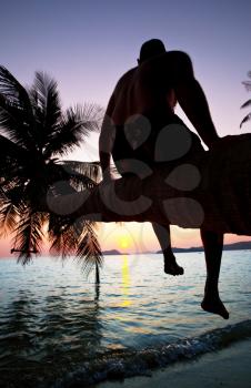 Royalty Free Photo of a Man Sitting on a Palm Tree at the Adaman Sea in Thailand