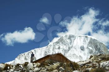 Royalty Free Photo of a Climber, Hut and Ranrapalka Peak in the Cordilleras