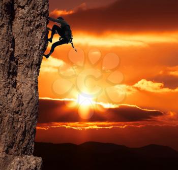 Royalty Free Photo of a Woman Climbing at Sunset