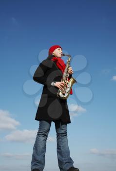 Royalty Free Photo of a Woman Playing a Saxophone Outside