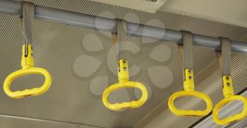 Royalty Free Photo of Yellow Handholds on a Bus