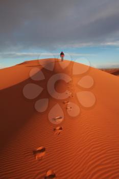 Royalty Free Photo of a Man Walking in the Desert