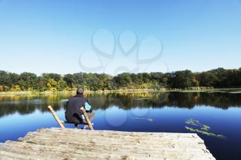 Royalty Free Photo of a Man Sitting at a Lake