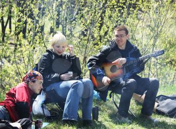 Royalty Free Photo of a People Having a Picnic and Playing Guitar