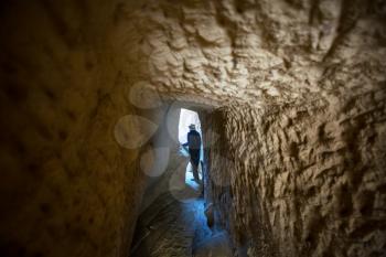 Tourist walking at tunnel of the underground City in Cappadocia, Turkey.