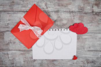 Valentine Day background with red envelope and wooden hearts