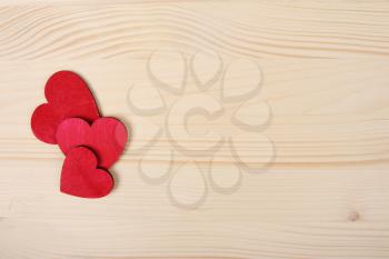 Red wooden Valentine Day hearts on board