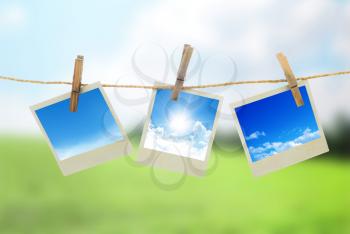 Three instant photos with sky inside hanging on the clothesline