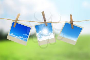 Three instant photos with sky inside hanging on the clothesline
