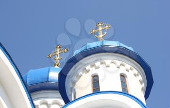 Dark blue church domes against the blue sky and gold crosses nearby