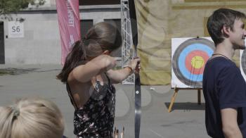 BARNAUL - AUGUST 16: Attractive female archer bending a bow and aiming in the target on August 6, 2019 in Barnaul, Russia.