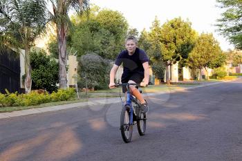 Young Boy Riding Bicycle on Tarred Urban Road