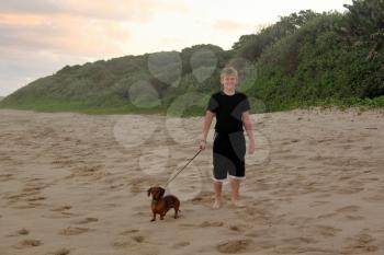 Picture of a Boy Walking His Dogs on a Beach