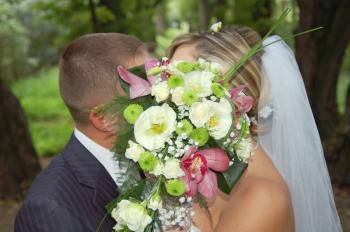 a groom and fiancee kiss after a bouquet horizontal