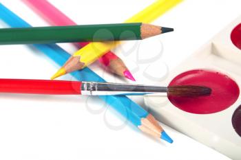 crayons coloured pencils and brush for paints isolated on white background