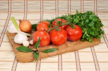 fresh tomatoes on a branch with vegetables