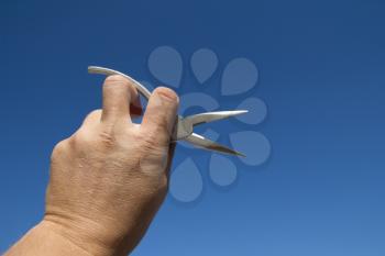 Pliers in hand man on a background of blue sky