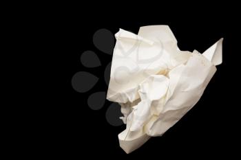 A crumpled paper ball in a black background