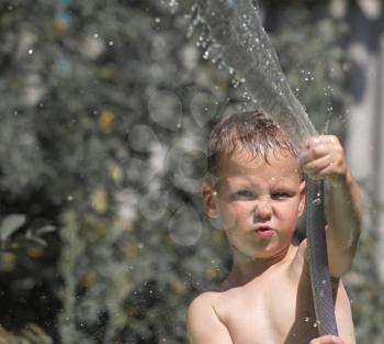 boy squirting water from a hose