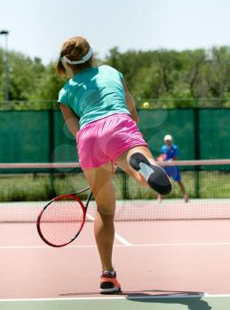 girl with a racket playing tennis on the court .
