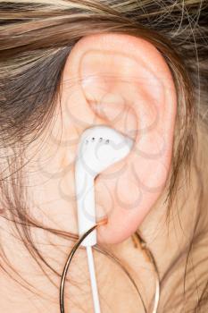 White Earphones in a Girl's Ear