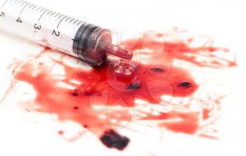 syringe and red blood on white background