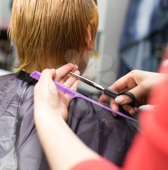 Female hair cutting scissors in beauty salon