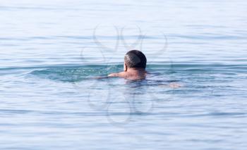 man bathes in the lake on the beach