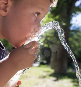boy drinking water outdoors