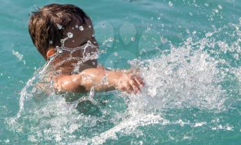 boy swims with a splash in the water park