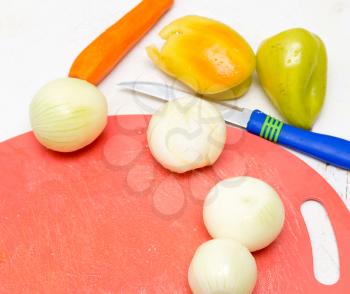 onions, carrots, and peppers on a white background